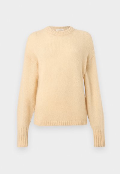 Pull tricot à manches longues de couleur crème avec des poignets et un ourlet côtelés, et un col rond.