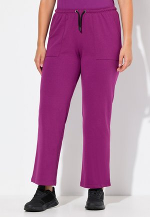 Lilla sweatpants med elastisk talje, snor og to forlommer. Stoffet er blødt og strækbart, med en løs pasform og flagrende ben.