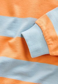 Striped sweater featuring orange and light blue colors, soft fabric, ribbed cuffs, and distinct horizontal stripes.