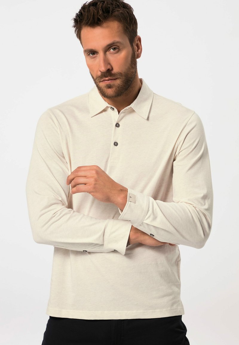 Camisa polo de manga larga en algodón color beige claro con cuello, que cuenta con tres botones en la parte delantera y puños abotonados.
