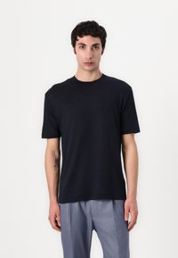 Marineblå kortermet crewneck t-skjorte laget av lett stoff, med en avslappet passform og glatt tekstur. Ingen synlige mønstre eller dekorasjoner.