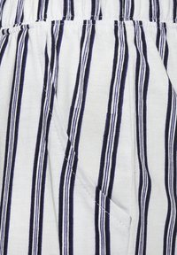 Striped fabric featuring narrow navy and white vertical lines, with a textured weave and an elastic waistband. Pocket detail visible.