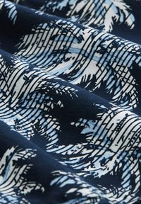 Textilstoff mit einem Wellenmuster in Weiß und Hellblau auf einem marineblauen Hintergrund, mit einer strukturierten Webart.
