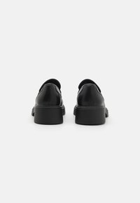 Černé kožené boty s nízkou, masivní podešví. Zaoblená podešev a hladký povrch. Minimalistický design, bez viditelného kování nebo akcentů.