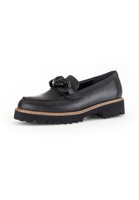 Black leather loafer with a decorative tied bow, textured upper, and a chunky black rubber sole with a contrasting tan stitching detail.