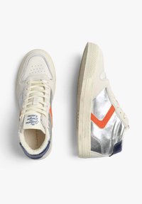 Buty sportowe w kremowym kolorze z srebrnymi akcentami, pomarańczowymi detalami i niebieską piętą; posiadają sznurówki, perforowany czubek i teksturowaną podeszwię.