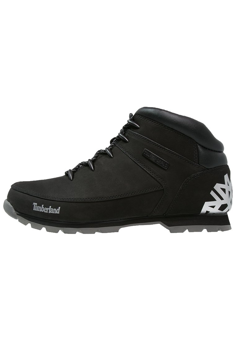 Botas de senderismo de cuero negro con un diseño de caña alta, puntera reforzada, suela texturizada y acentos geométricos blancos en el talón.