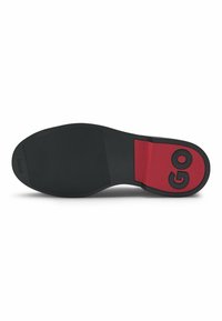 Shoe sole with a black rubber bottom, featuring a textured surface and a red heel accent with "GO" embossed in black.