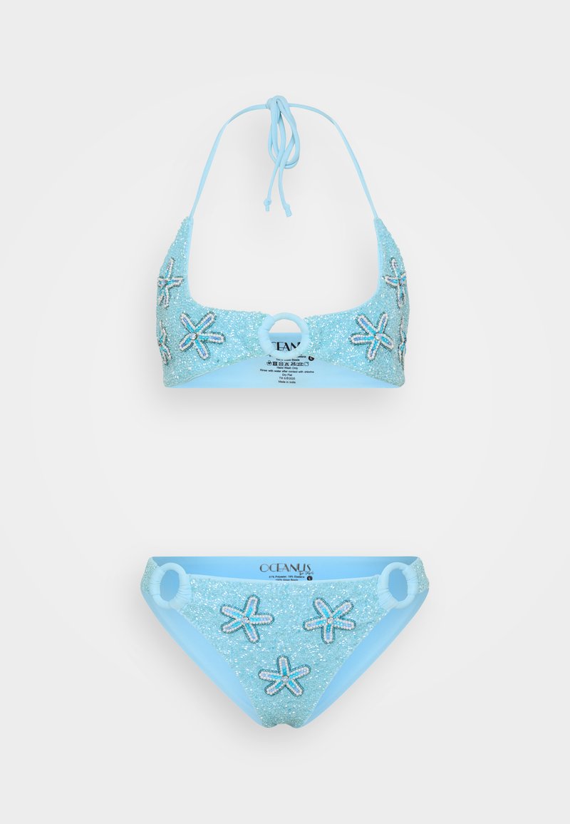 Svetlomodrý bikiny set s trblietavým povrchom. Hlavný vrch a spodná časť majú ozdoby v tvare morských hviezd. Obsahuje detail v tvare kruhu.