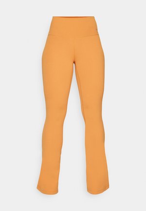 Leggings laranja com corte flare e um cós alto, feitos de um tecido elástico. Apresentam uma textura suave e uma marcação discreta na cintura.