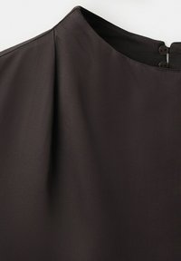 Close-up of a dark brown garment neckline with two small black buttons on a plain white background.