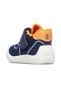 Scarpa per bambino in maglia blu navy con dettagli arancioni, cinturino in velcro, suola bianca testurizzata e dettaglio del logo ricamato sul retro.