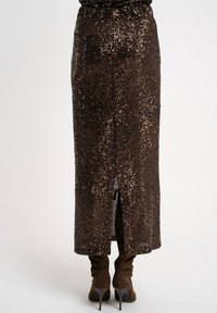 Brązowa spódnica maxi z cekinami, z wysokim rozcięciem z tyłu, posiadająca dopasowaną talię i połyskującą teksturę, która mieni się w świetle.
