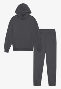 Sudadera con capucha gris oscuro con hombros caídos y pantalones de chándal a juego que cuentan con una cintura elástica y piernas ajustadas.