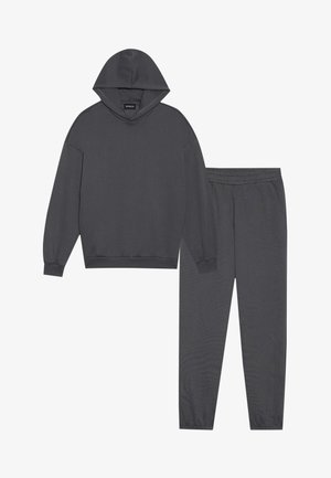 Dark gray hooded sweatshirt with dropped shoulders and matching sweatpants featuring an elastic waistband and tapered legs.