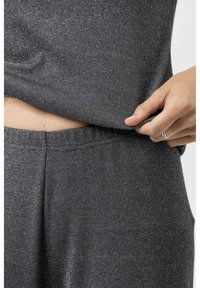 Grijze, gestructureerde stoffen set met een geribbeld materiaal en een lichte glans. Verstelbare tailleband zichtbaar, die flexibiliteit en comfort biedt.