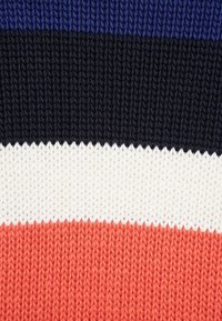 Tissu tricoté présentant des rayures horizontales en bleu marine, violet, blanc et corail. Fil texturé avec un motif régulier et une finition lisse.