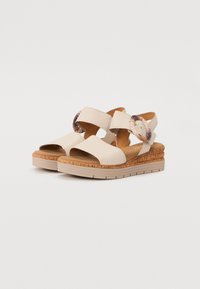 Beige platform sandals with dual adjustable straps, cork accent, and textured sole. Open-toe design for breathability and comfort.