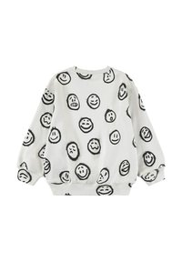 Vit sweatshirt med svarta smiley face-mönster. Löst sittande med rundad halsringning och avslutade ärmar. Mjukt tyg.