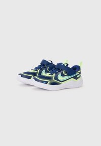 Chaussures de sport bleu et vert fluo avec une tige en mesh, une sangle Velcro, un design léger et des semelles en caoutchouc blanches.