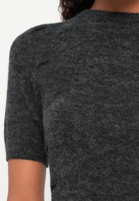 Σκούρο γκρι κοντομάνικο πλεκτό πουλόβερ με υφή, διαθέτοντας στρογγυλή λαιμόκοψη και υποτονικές λεπτομέρειες στους ώμους.