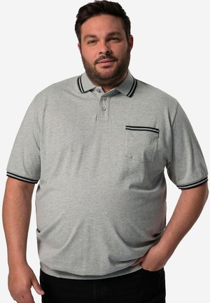 Šedé polo tričko s tříknoflíkovou légou, krátkými rukávy a černými pruhy na límci a manžetách. Obsahuje kapsu na levém prsu.