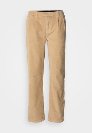 Béžové kordové kalhoty s rovný střihem, které mají dva přední záhyby, poutek na opasek a hladkou texturu. Žádné viditelné kovové prvky ani vzory.