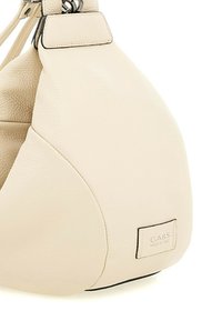 Borsa a tracolla in pelle crema con una forma semi-strutturata, caratterizzata da una superficie testurizzata, dettagli neri e un'etichetta visibile con la scritta "GABS - MADE IN ITALY."