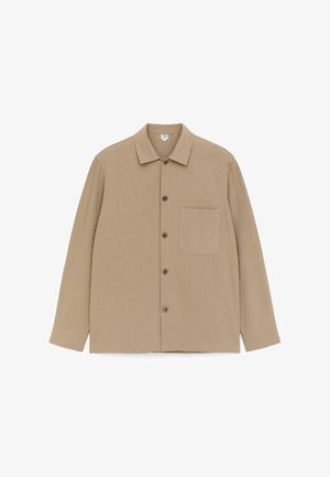 Ilgas smėlio spalvos marškiniai su sagomis, apykakle, kairėje pusėje viena krūtinės kišenė ir priekyje smėlio spalvos sagos.