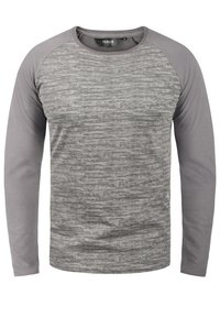 Langærmet t-shirt i lyse og mørke grå nuancer, med en tekstureret krop og glatte ærmer. Crew neck design med raglan stil.