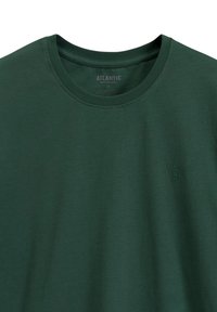 Ciemnozielona koszulka z krótkim rękawem wykonana z miękkiego materiału, z okrągłym dekoltem i małym, subtelnym logo na piersi.