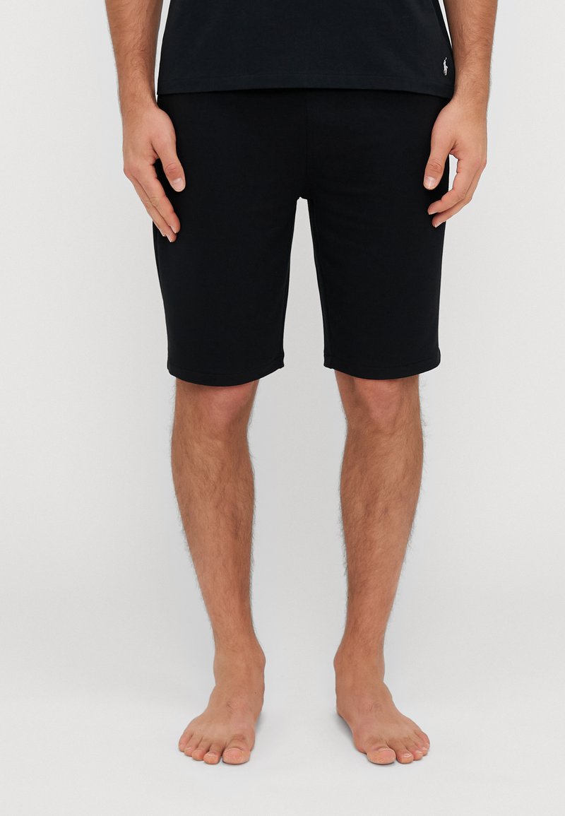 Shorts negri din bumbac, cu o croială slim, care ajung până la jumătatea coapsei. Au un tiv simplu, fără modele vizibile sau elemente suplimentare.