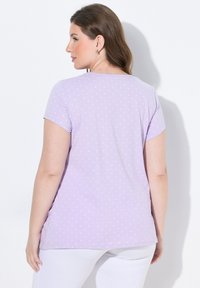 Lavendel kortærmet t-shirt med prikket mønster. Blødt stof, rund halsudskæring og en afslappet pasform, designet for komfort.