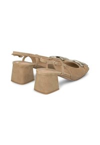 Sandali con tacco in suede beige, dotati di una fascia posteriore, tacco a blocco quadrato e dettagli a fiocco decorativi sulla parte anteriore. Texture liscia e design semplice.