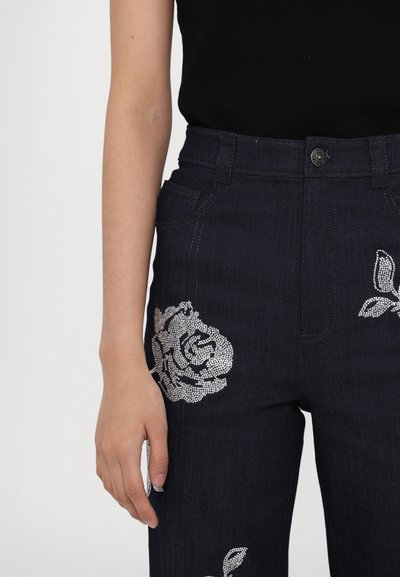 Donkerdenim jeans met zilveren rhinestone bloemenpatronen aan de voorkant, met een hoge taille en klassieke vijf-pocket stijl.