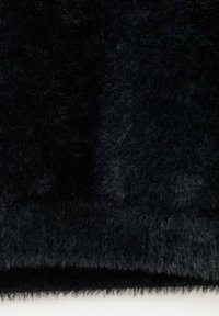 Tela de piel sintética negra con una textura suave y esponjosa. La superficie parece estar densamente tejida, mostrando longitudes variables de fibras para mayor profundidad.