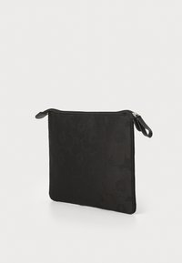 Sort lynlås-pung lavet af tekstureret stof med et blomsterdesign. Har et fladt, rektangulært design og en slank, glat overflade.
