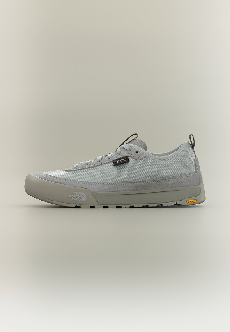 Ανοιχτό γκρι sneaker χαμηλού προφίλ με επάνω μέρος από πλέγμα και σουέντ, κλείσιμο με κορδόνια, λογότυπα The North Face και Vibram στη σόλα και στο πλάι.