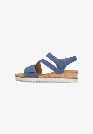 Blauwe canvas wiggen sandalen met twee klittenbandsluitingen, kurken wiggenhak, witte gekartelde zool en een gladde bruine voetbed.