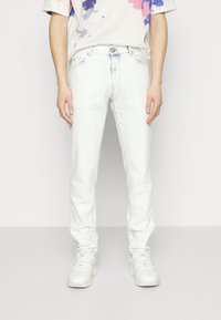 Světle modré džíny s rovný fit, s klasickým pětipocket designem a jemnými detaily prošívání. Nosit s bílými teniskami.