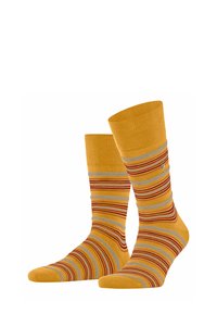 Gelbe Socken mit bunten Streifen in Rot und Grau. Stricktextur, Knöchellänge, mit geripptem Bündchen und einem kleinen Logodetail.