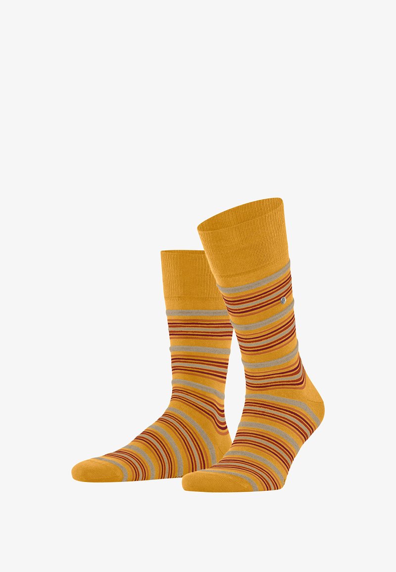 Gelbe Socken mit bunten Streifen in Rot und Grau. Stricktextur, Knöchellänge, mit geripptem Bündchen und einem kleinen Logodetail.