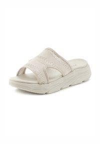 Light beige sandals with a textured, breathable fabric upper. Open-toe design and thick sole for comfort. Flat sole with subtle tread pattern.