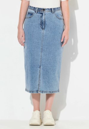 Jupe midi en denim, bleu clair, avec une coupe droite, cinq poches, passants de ceinture et fermeture à bouton à l'avant. Portée avec des baskets blanches.