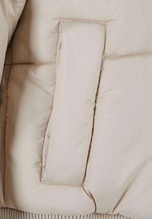Beige puffer-jacka i tyg med en slät yta; har en stor, rektangulär ficka och ribbad stickad kant.