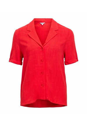 Blusa roja de manga corta con botones, cuello con muesca y puños doblados, ligeramente más larga en la parte posterior.