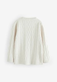 Svetle béžový svetr s pleteným vzorem a dlouhými rukávy, zdobený diamantovými a žebrovanými texturami, s kulatým výstřihem a bočními rozparky na lemu.