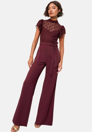 Burgundy overalls csipkés rövid ujjal, testhezálló felsőrésszel és széles szárú nadrággal. Övvel ellátott derékrész és textúrázott felsőrész jellemzi. Sima anyag.