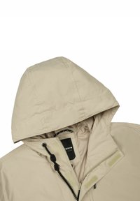 Beige hættetrøje med lynlås foran, justerbare snore og velcrobånd. Glat tekstur med et minimalistisk design.