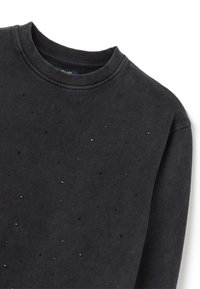Sudadera negra con cuello redondo, tela texturizada y pequeños rhinestones dispersos como acento. Diseño suave y casual.